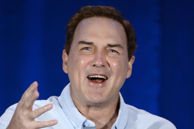 Comedian Norm MacDonald, gesturing and talking.